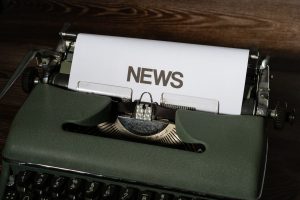 A retro typewriter featuring a 'NEWS' headline typed on white paper against a wooden surface. — Czy Slotsvader Casino to Rzet