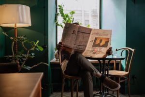 A man sits in a cozy café corner, enjoying a newspaper and relaxed ambiance. — FelixSpin: Vittorie Veloci e Emozioni Instanta