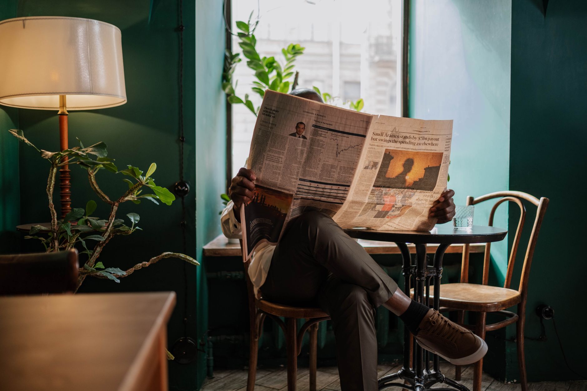 A man sits in a cozy café corner, enjoying a newspaper and relaxed ambiance. — FelixSpin: Vittorie Veloci e Emozioni Instanta