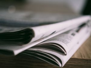 Stack of folded newspapers on a wooden table with a focus on printed pages. — Maximising Your Winnings at Yukon Gold Casino: