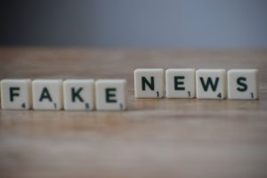 Scrabble tiles spelling 'Fake News' on a wooden surface highlighting misinformation. — Sensible Medical insurance Preparation
