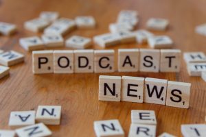 Wooden letter tiles spelling out 'PODCAST NEWS' on a wooden surface. — test123123