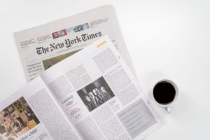 Flat lay of a coffee cup and The New York Times newspaper, ideal for business and lifestyle themes. — test123123